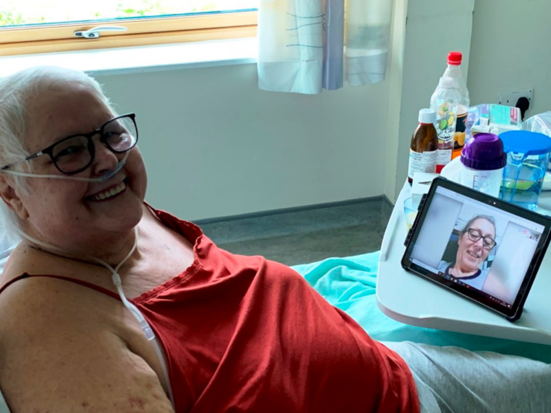 A patient talks a loved one using a tablet